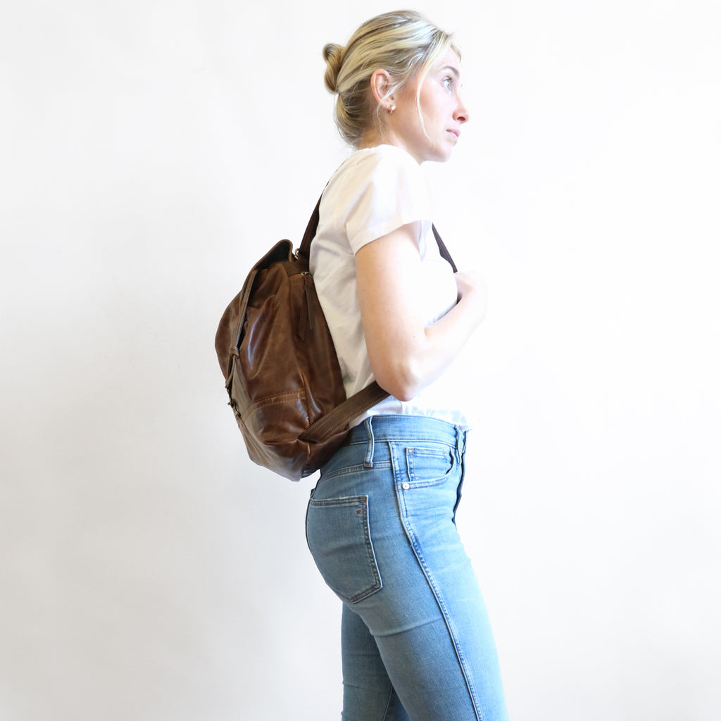 Side view of model wearing 1904 maxwell, size medium, as a backpack.