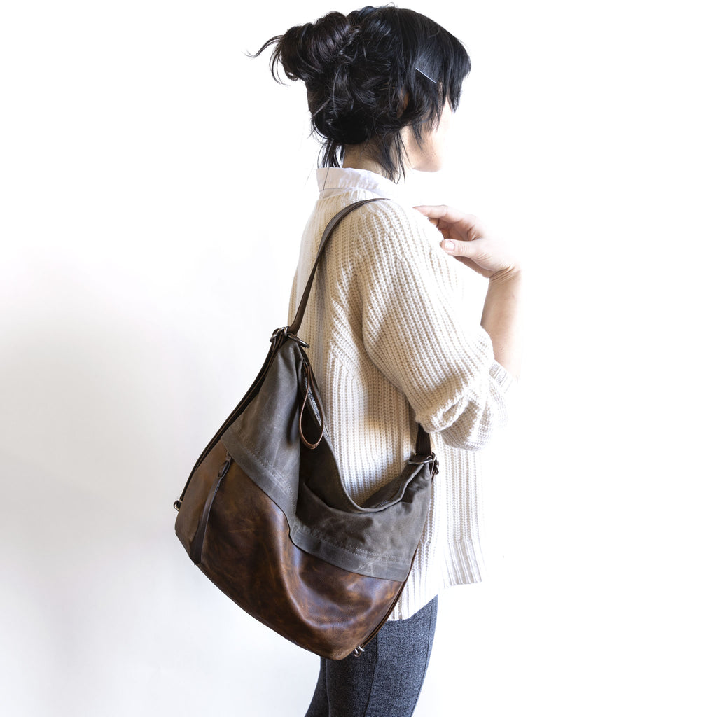 Model holding an original city safari single zip, size large, on shoulder.
