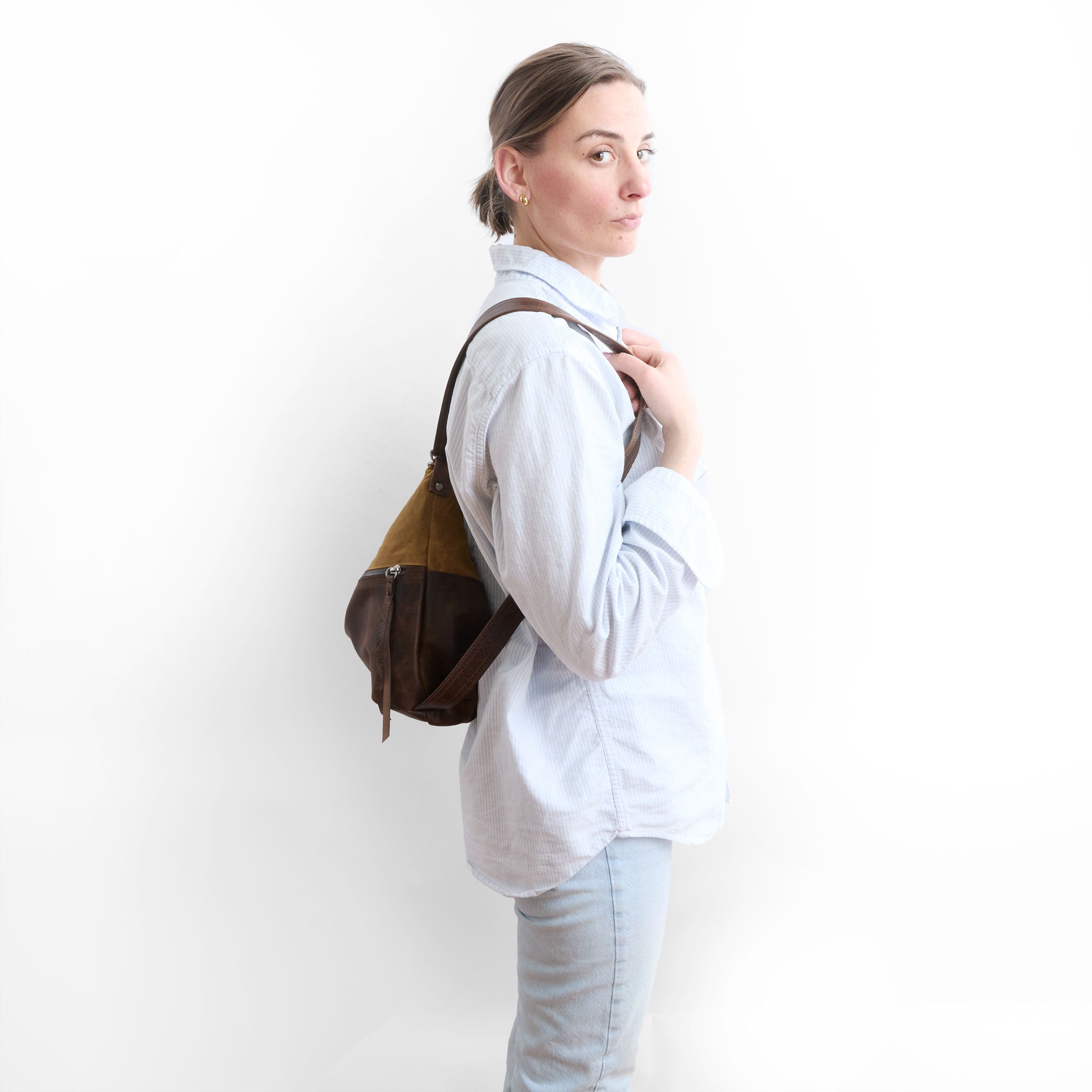 side view of medium city safari double zip in whiskey canvas and rustic pecan in backpack mode